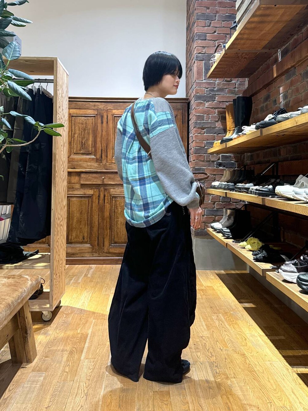 グレー系のスウェット、ブラック系のパンプス、ブラウン系のショルダーバッグを着用したレディースの秋コーディネートの3枚目の写真