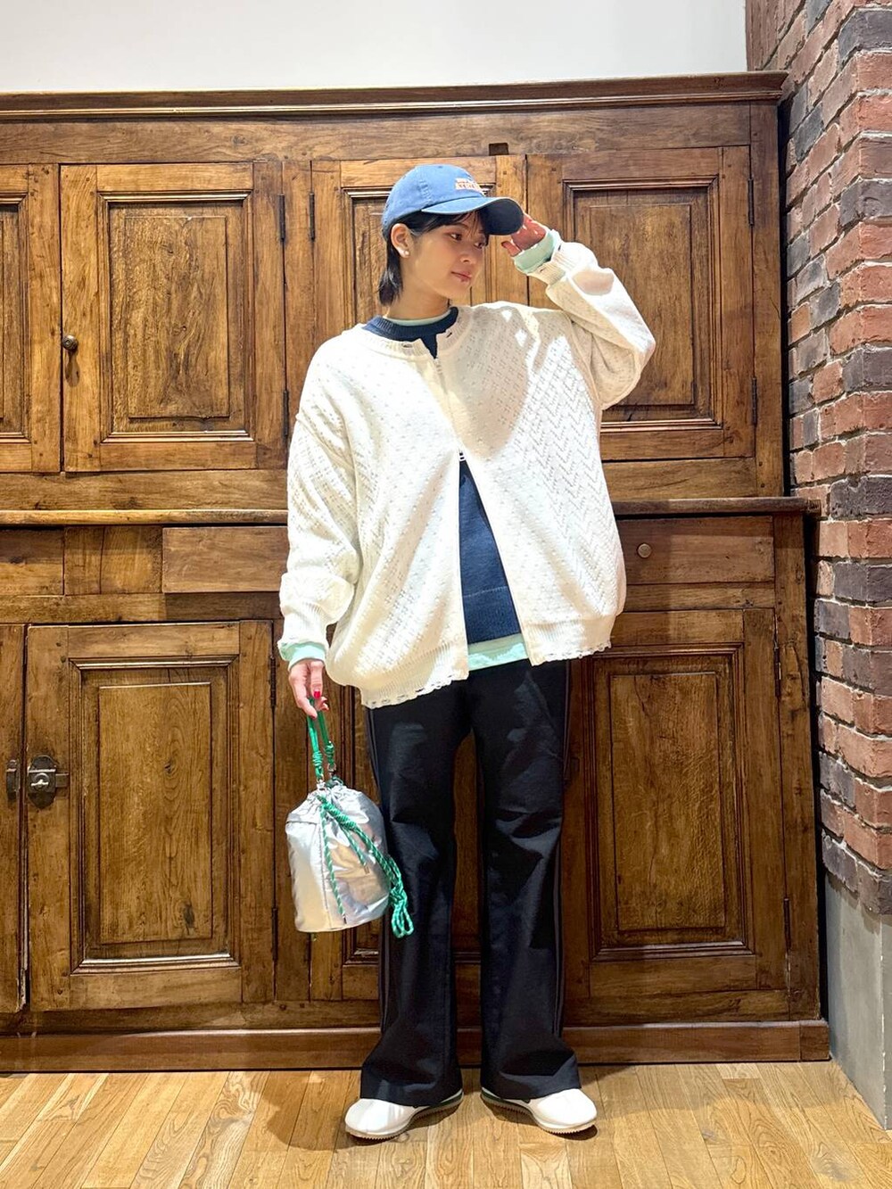 ホワイト系のブルゾン、ブルー系のニット/セーター、グリーン系のTシャツ/カットソーを着用したレディースの冬コーディネートの5枚目の写真