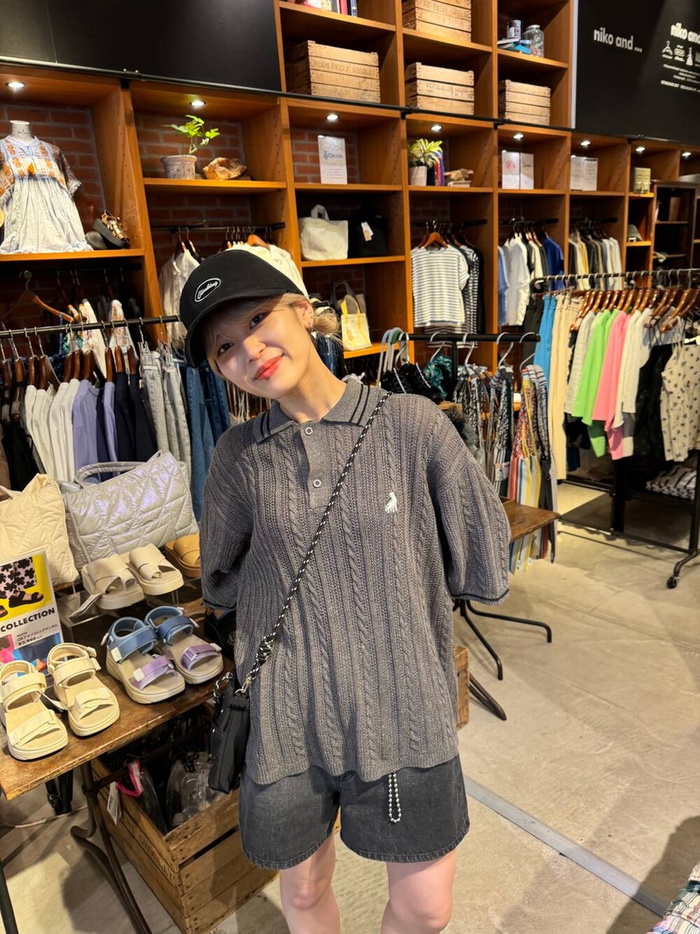 ブラック系のショルダーバッグ、ブラック系のサンダル、ブラック系のキャップを着用したレディースの春コーディネートの5枚目の写真