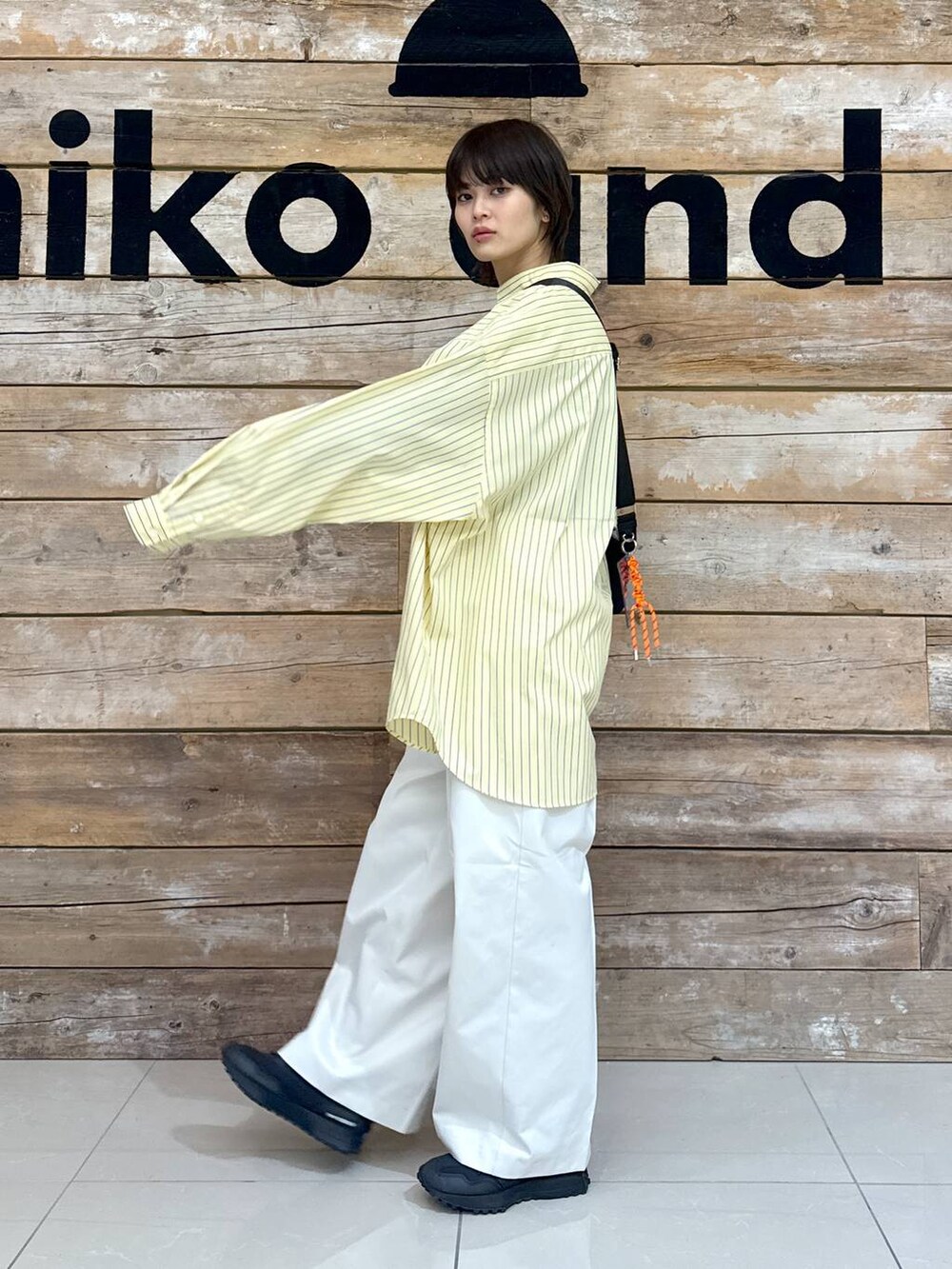 ベージュ系のチノパンツ、イエロー系のシャツ/ブラウス、ブラック系のスニーカーを着用したレディースの冬コーディネートの5枚目の写真