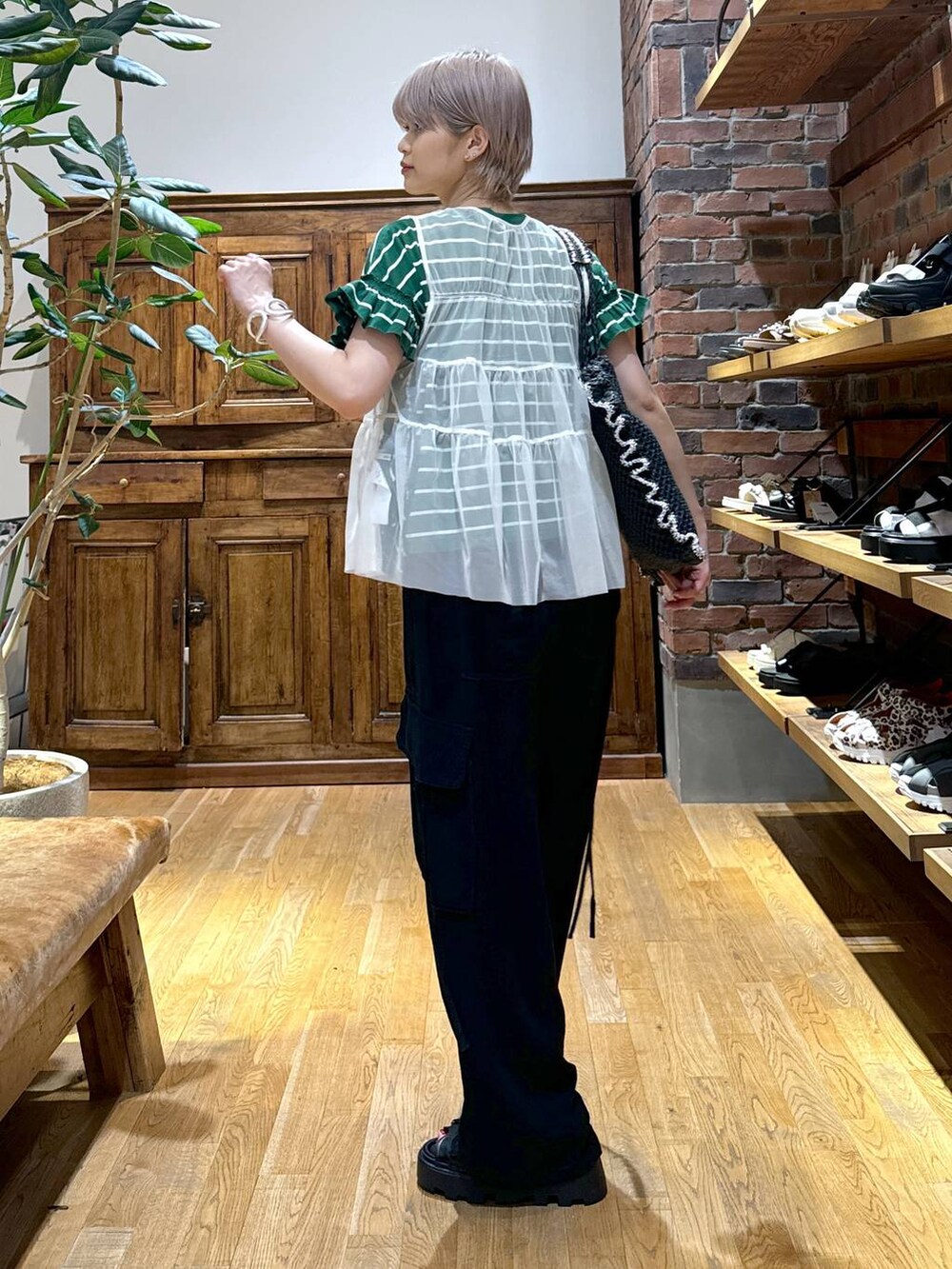 ブラック系のサンダル、ブラック系のカーゴパンツ、ホワイト系のベストを着用したレディースの夏コーディネートの3枚目の写真