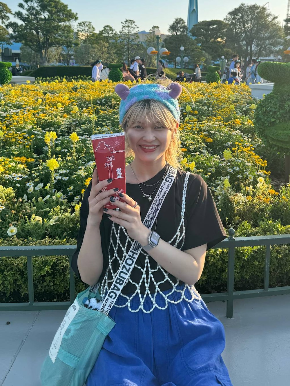 ホワイト系のベスト、ブラック系のサンダル、ブルー系のカーゴパンツを着用したレディースの春コーディネートの3枚目の写真