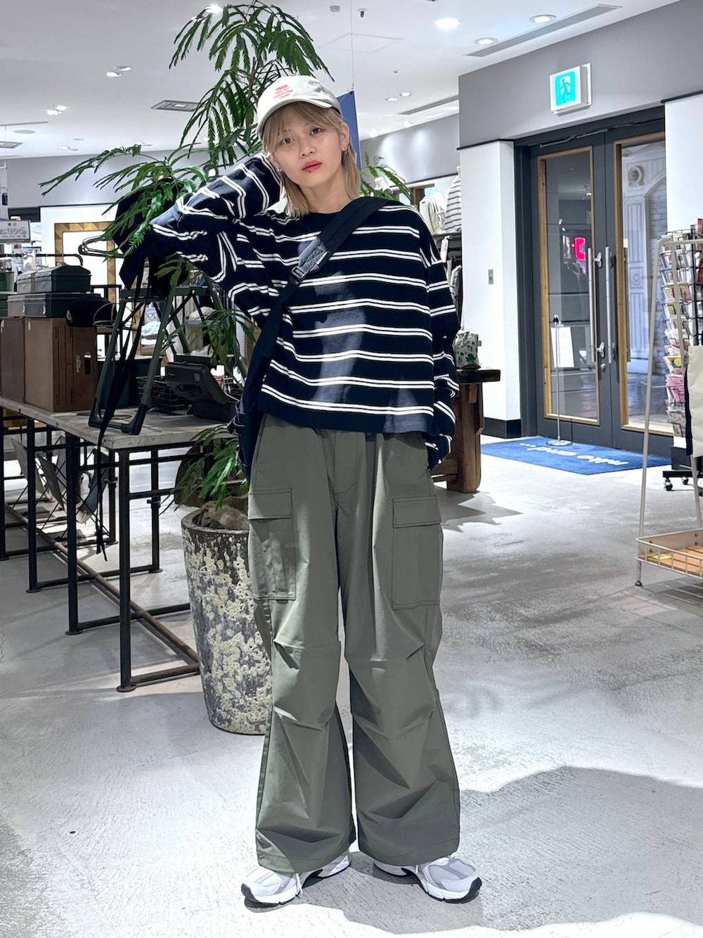 グリーン系のカーゴパンツ、ブラック系のTシャツ/カットソー、グレー系のスニーカーを着用したメンズの春コーディネートの6枚目の写真