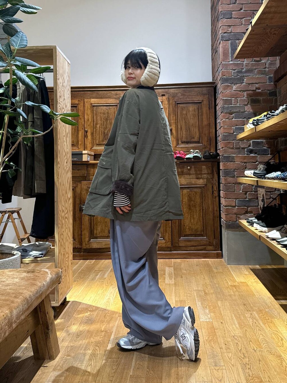 グレー系のスニーカー、グリーン系のブルゾン、ベージュ系のイヤーマフを着用したレディースの秋コーディネートの4枚目の写真