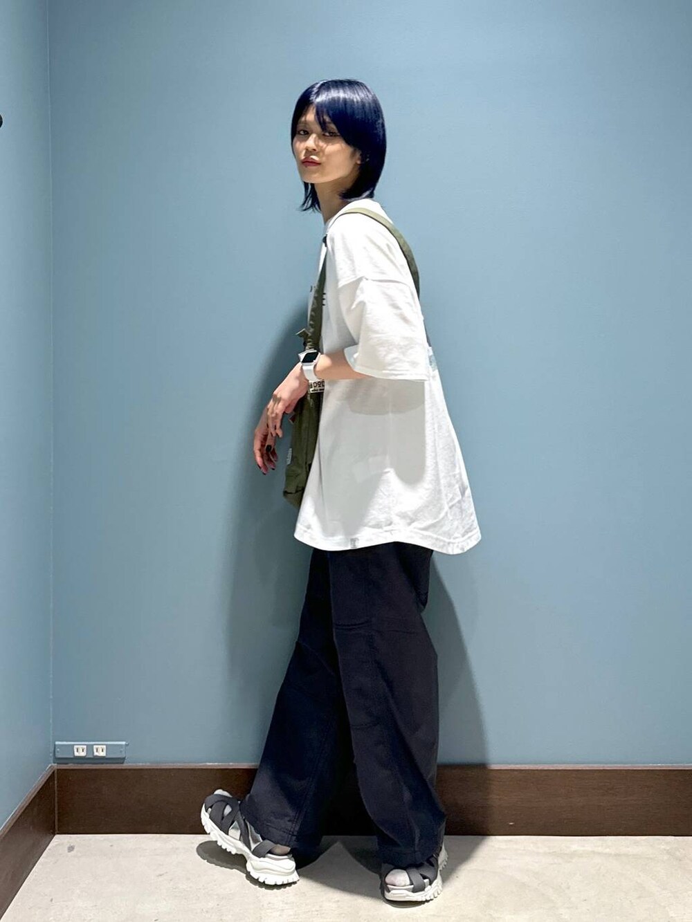 グレー系のその他パンツ、ホワイト系のTシャツ/カットソー、グリーン系のショルダーバッグを着用したレディースの春コーディネートの2枚目の写真