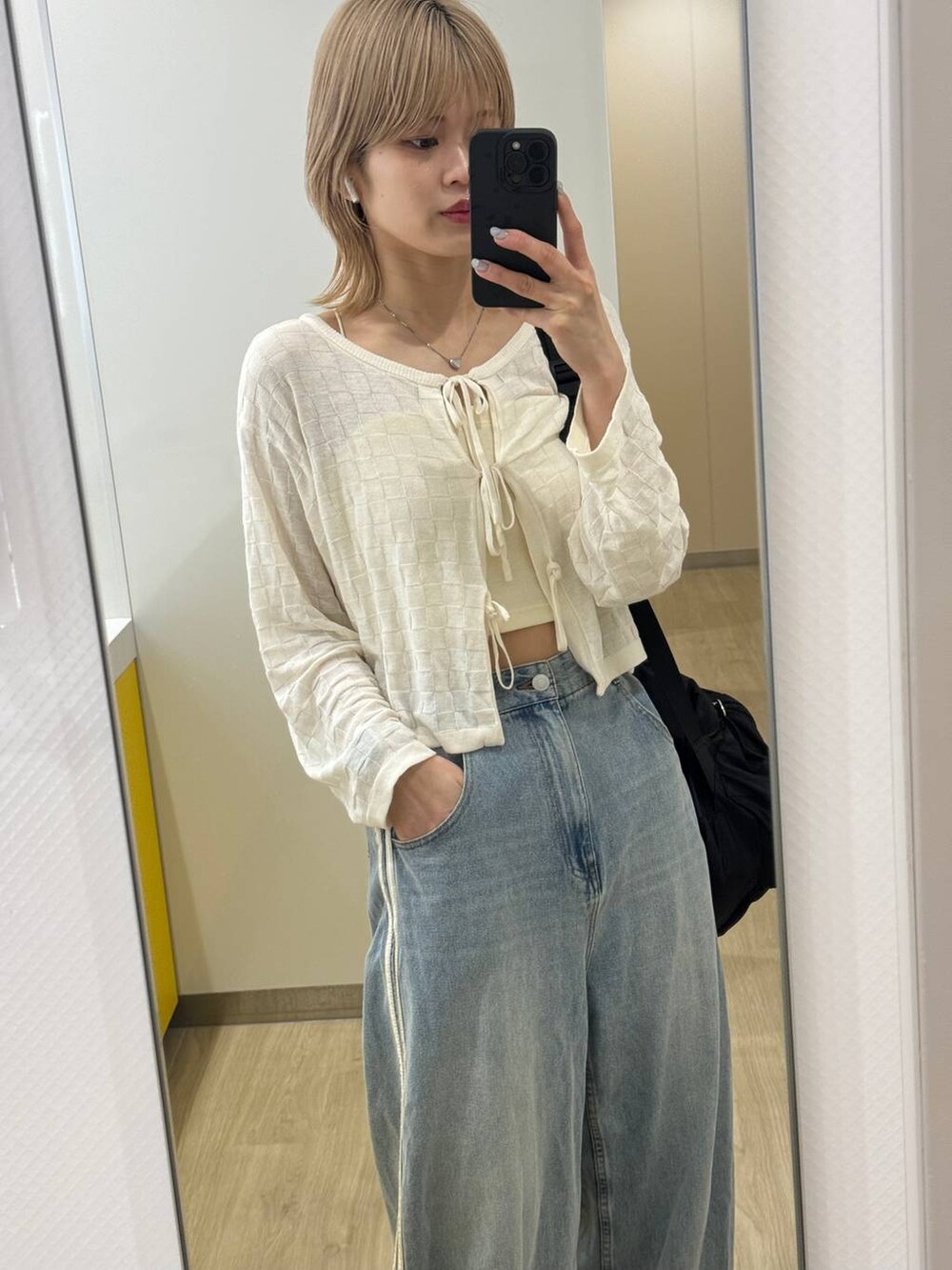 ベージュ系のキャミソール、ホワイト系のカーディガン/ボレロを着用したレディースの春コーディネートの3枚目の写真