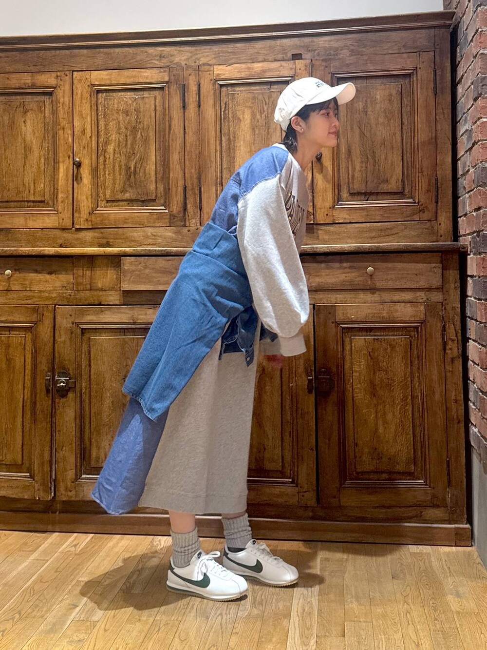 ブルー系のシャツ/ブラウス、グレー系のワンピース、ホワイト系のキャップを着用したレディースの冬コーディネートの2枚目の写真