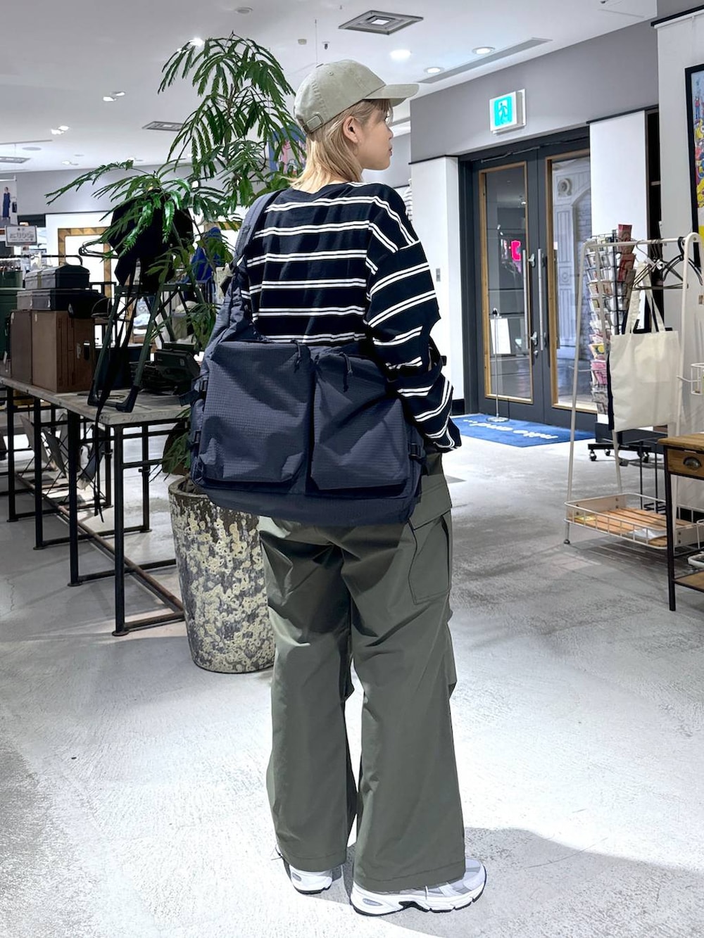 グリーン系のカーゴパンツ、ブラック系のTシャツ/カットソー、グレー系のスニーカーを着用したメンズの春コーディネートの7枚目の写真