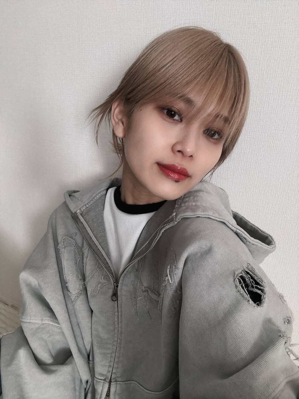 グレー系のパーカーを着用したレディースの春コーディネートの2枚目の写真