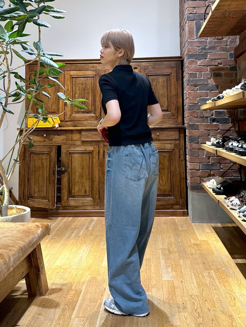 グレー系のスニーカー、ブラック系のカーディガン/ボレロ、レッド系の財布を着用したレディースの夏コーディネートの2枚目の写真