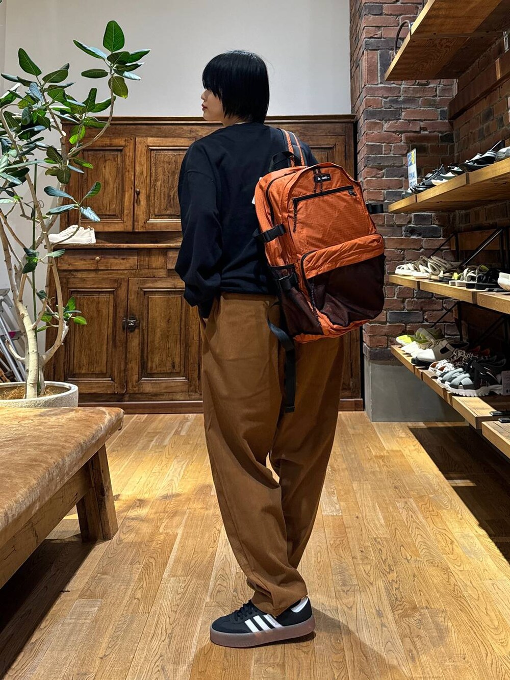 ブラック系のスニーカー、イエロー系のその他パンツ、ブラック系のスウェットを着用したレディースの秋コーディネートの4枚目の写真