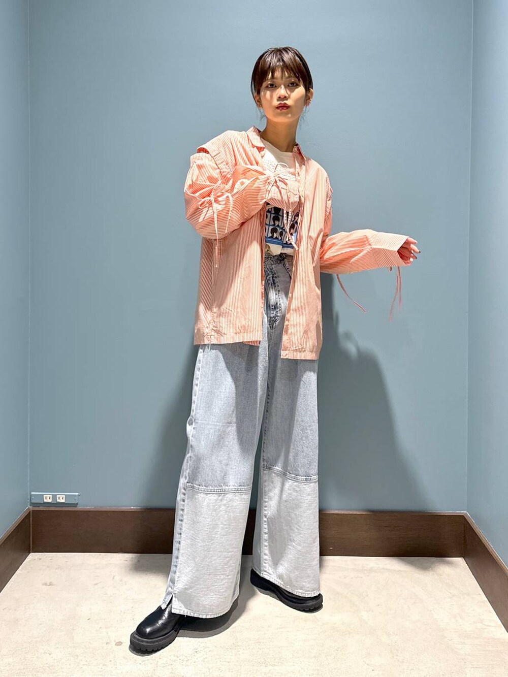 オレンジ系のシャツ/ブラウス、ホワイト系のTシャツ/カットソー、ブルー系のデニムパンツを着用したレディースの春コーディネートの3枚目の写真