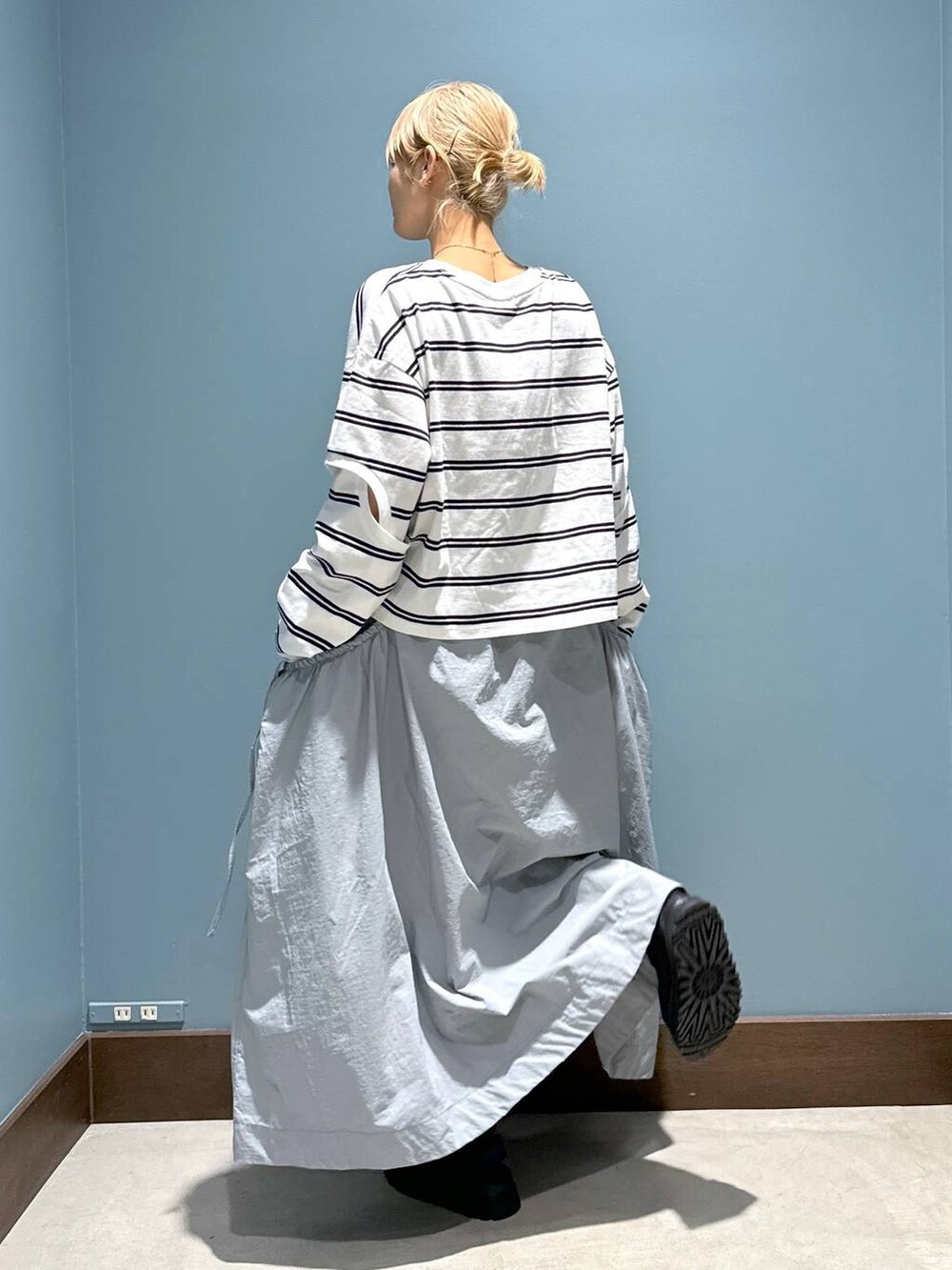 ホワイト系のTシャツ/カットソー、グレー系のスカート、ブラック系のサンダルを着用したレディースの春コーディネートの3枚目の写真