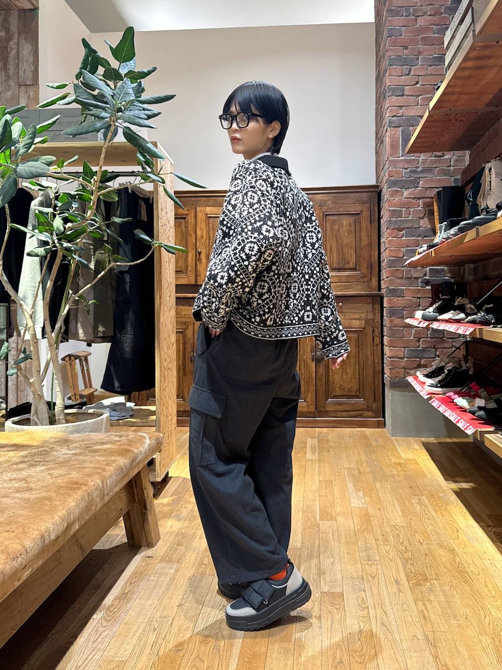 ブラック系のスニーカー、グレー系のカーゴパンツ、ブラック系のカーディガン/ボレロを着用したレディースの冬コーディネートの2枚目の写真