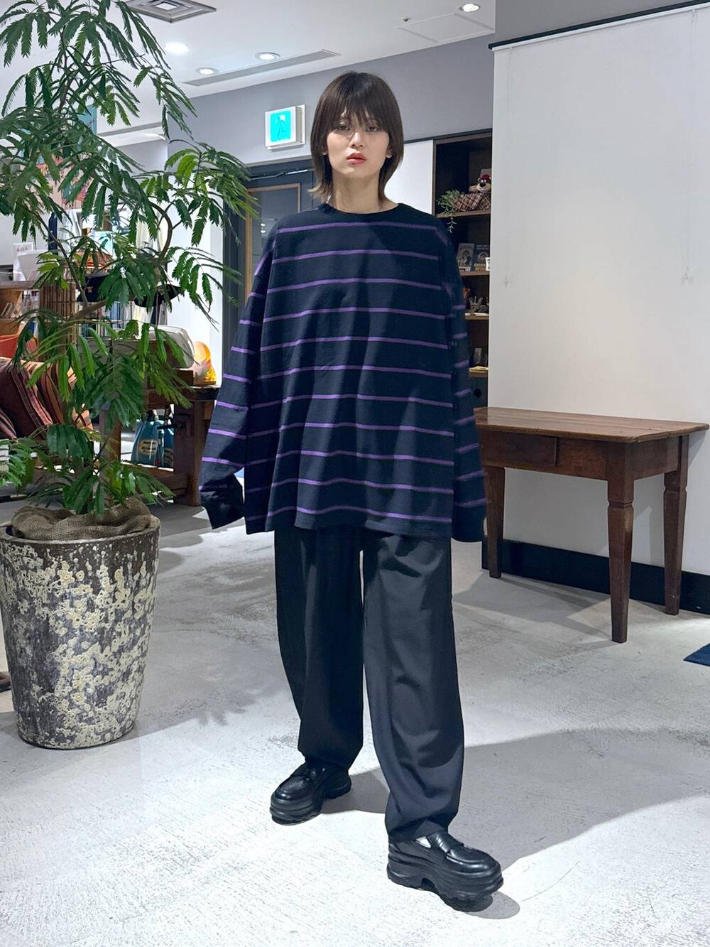 ブラック系のローファー、ブラック系のスラックス、グレー系のブルゾンを着用したレディースの冬コーディネートの8枚目の写真