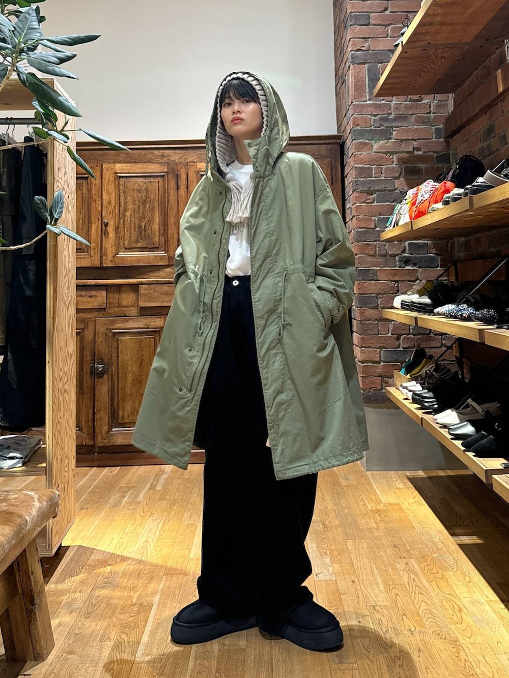 ブラック系のその他パンツ、グリーン系のモッズコート、ブラック系のスリッポンを着用したレディースの冬コーディネートの2枚目の写真