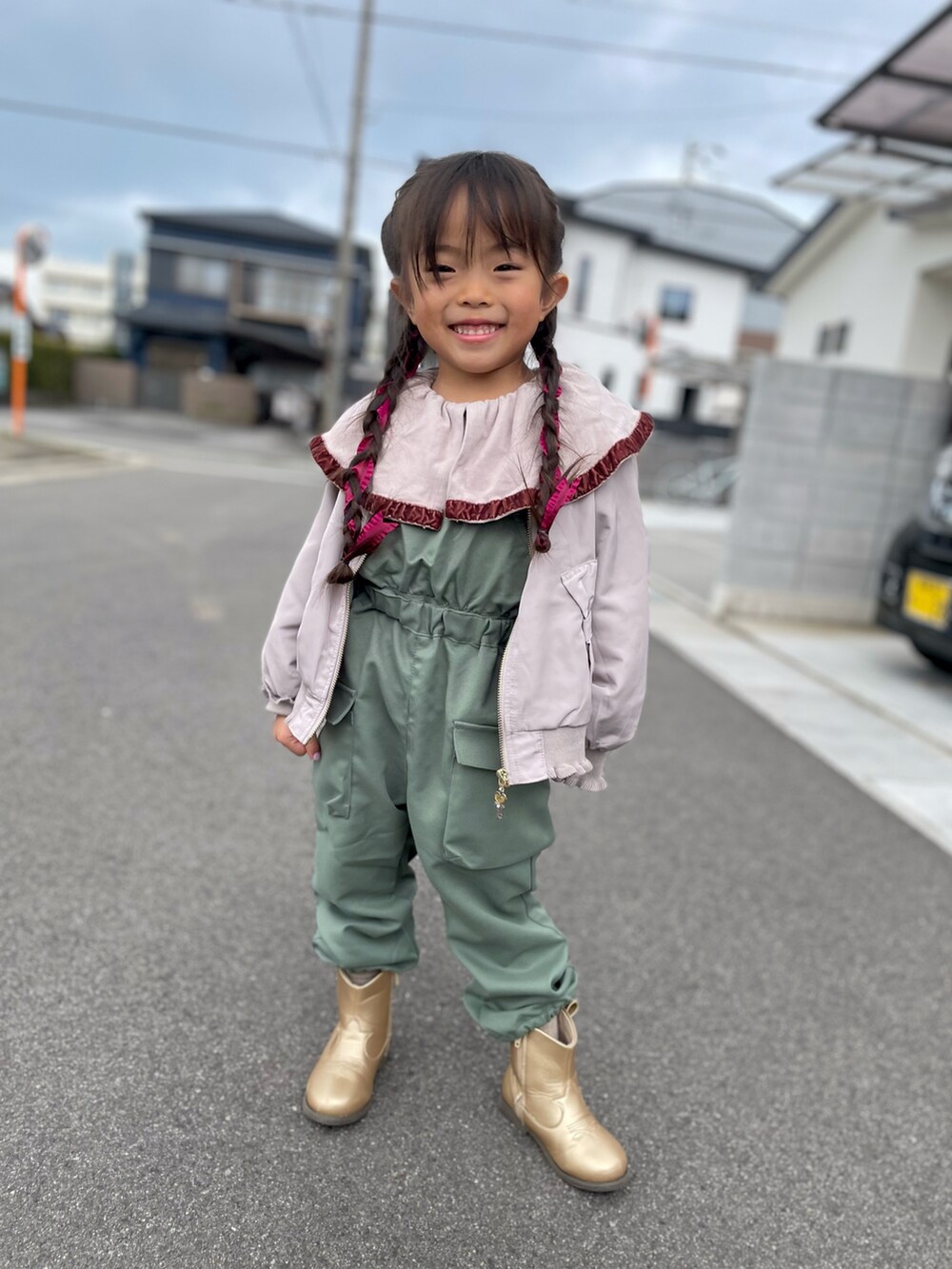 ピンク系のMA-1、ベージュ系のTシャツ/カットソー、グリーン系のサロペット/オーバーオールを着用したキッズの春コーディネートの3枚目の写真