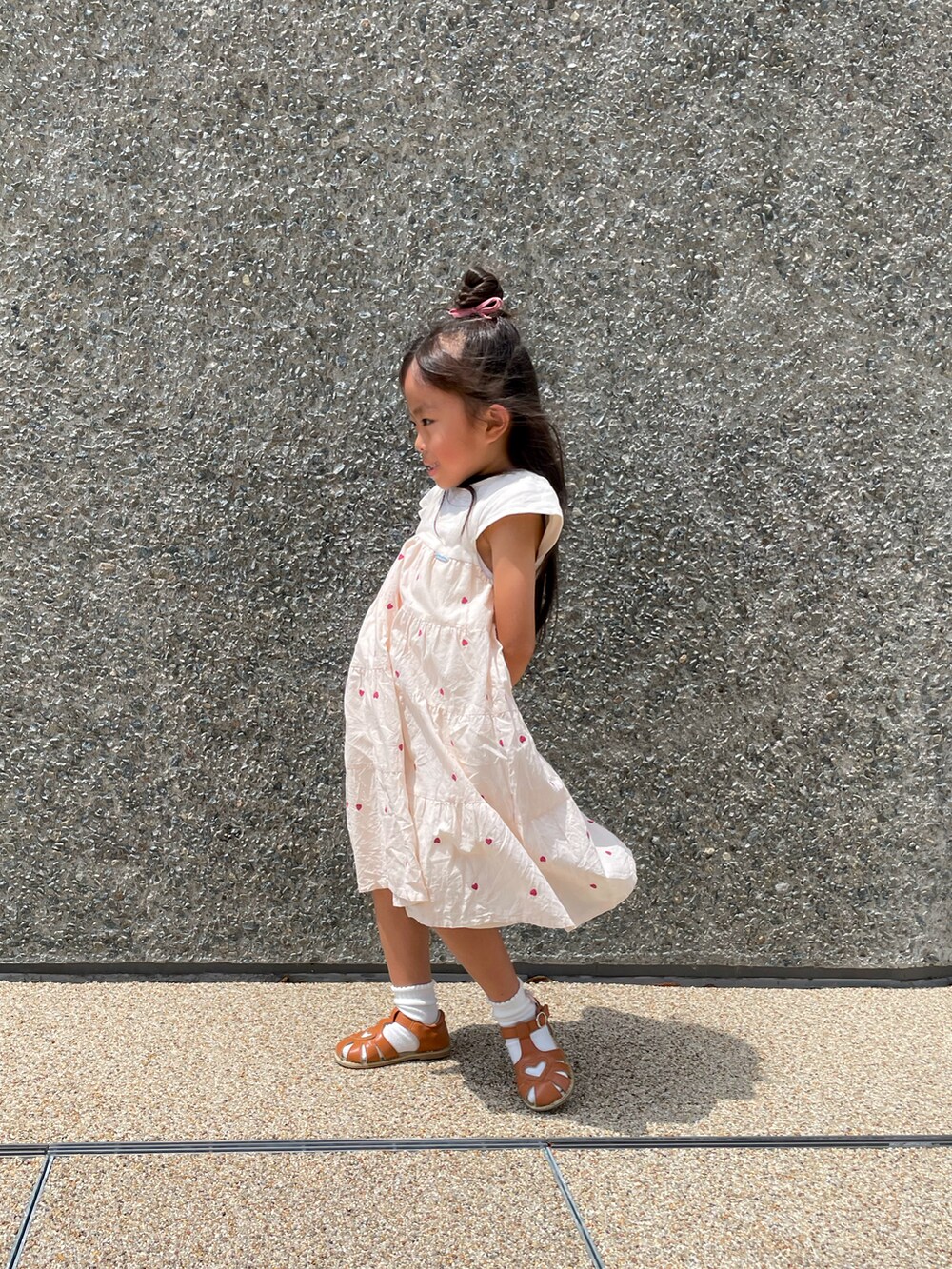 イエロー系のスニーカー、ホワイト系のワンピースを着用したキッズの夏コーディネートの2枚目の写真