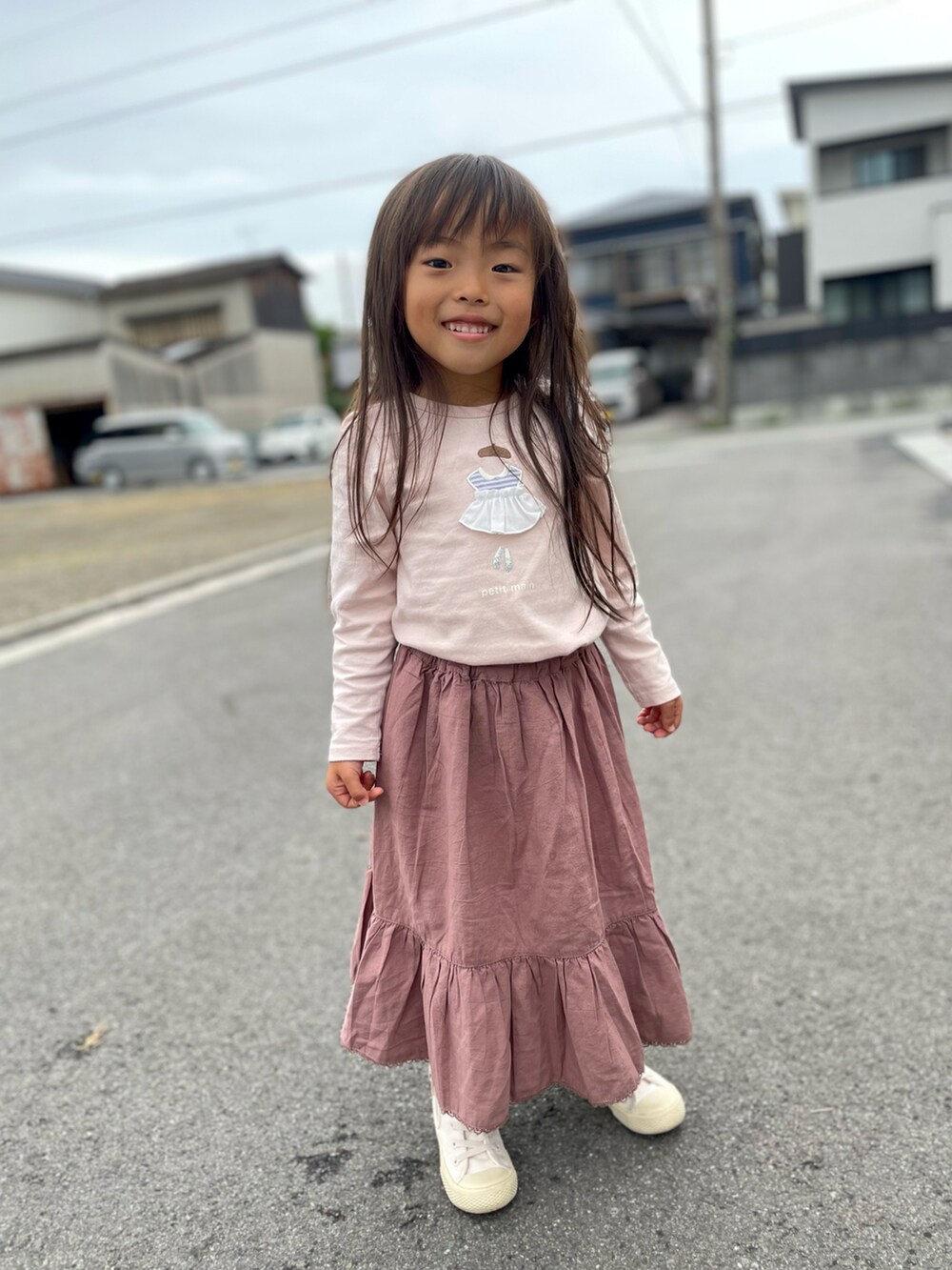 ピンク系のTシャツ/カットソー、ホワイト系のスニーカー、ブラウン系のスカートを着用したキッズの春コーディネートの2枚目の写真