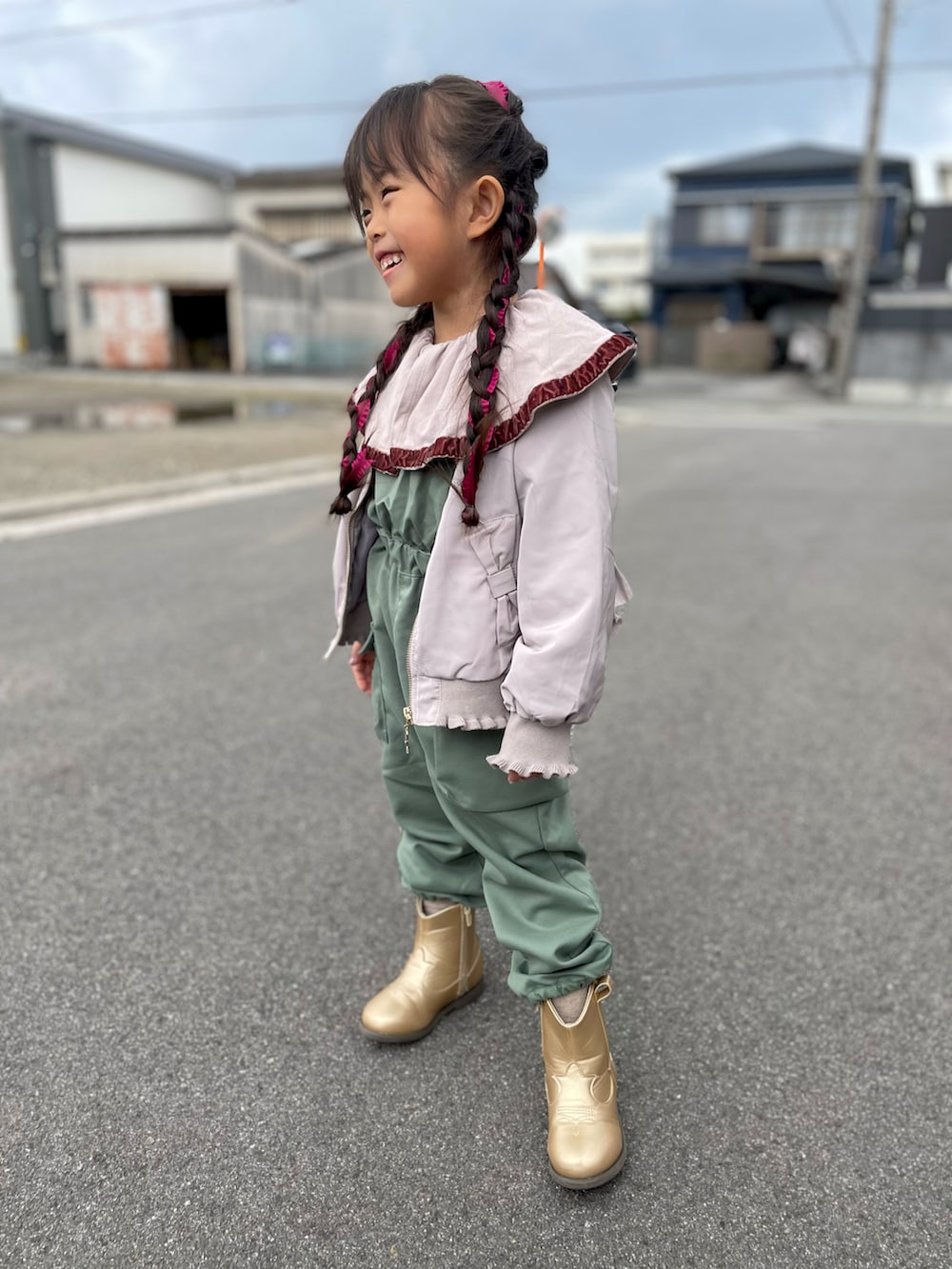 ピンク系のMA-1、ベージュ系のTシャツ/カットソー、グリーン系のサロペット/オーバーオールを着用したキッズの春コーディネートの2枚目の写真