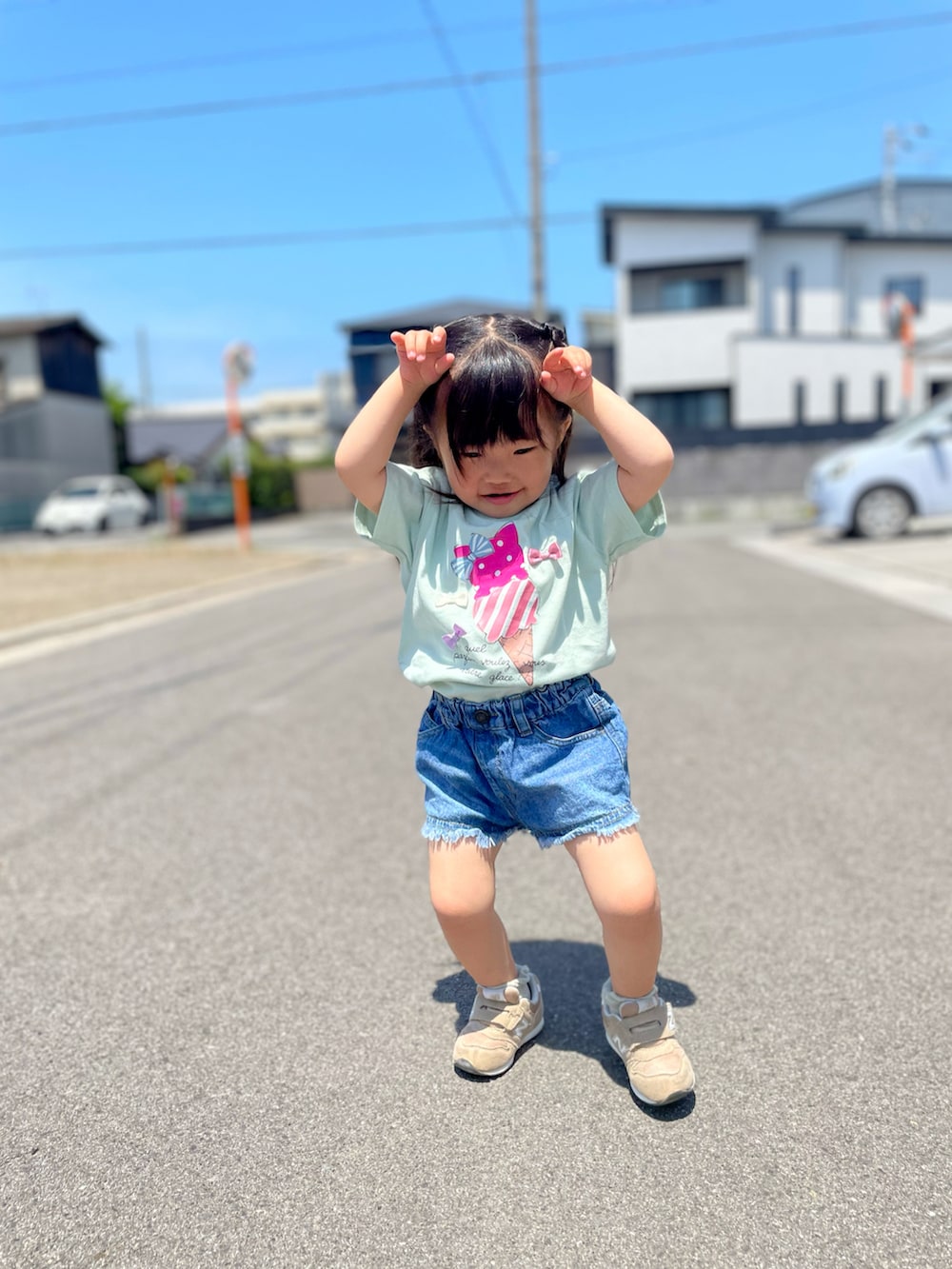 グリーン系のTシャツ/カットソー、ブルー系のデニムパンツ、ベージュ系のスニーカーを着用したキッズの春コーディネートの2枚目の写真