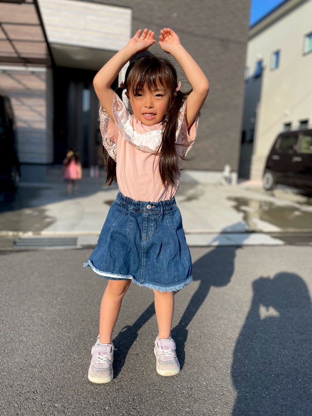 ピンク系のTシャツ/カットソー、パープル系のスニーカー、ブルー系のデニムパンツを着用したキッズの春コーディネートの2枚目の写真