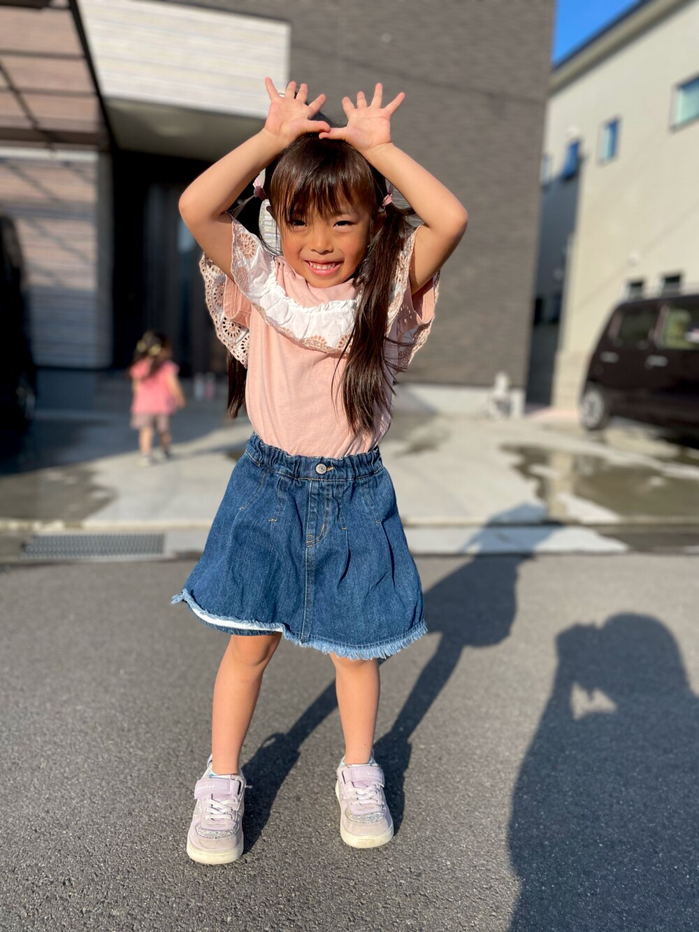 ピンク系のTシャツ/カットソー、パープル系のスニーカー、ブルー系のデニムパンツを着用したキッズの春コーディネートの3枚目の写真