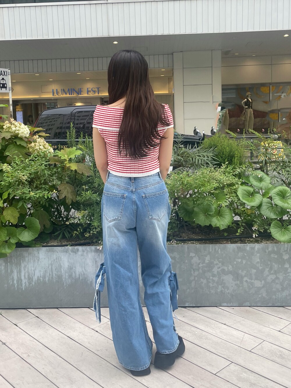 ブルー系のデニムパンツ、ブラック系のサンダル、レッド系のニット/セーターを着用したレディースの夏コーディネートの4枚目の写真