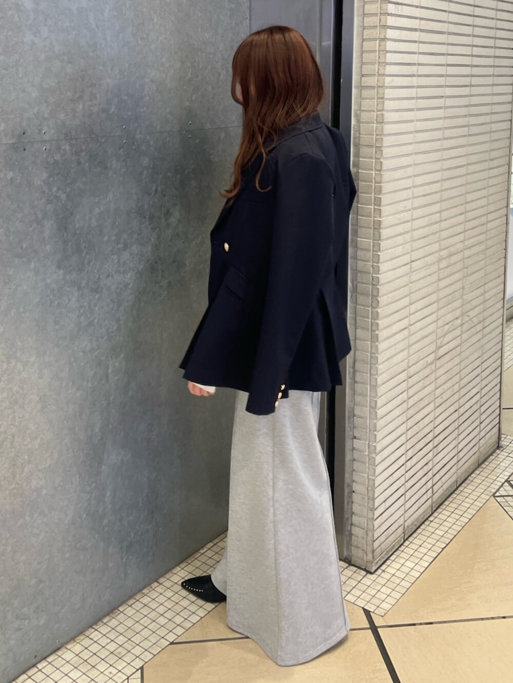 イエロー系のニット/セーター、ブルー系のノーカラージャケット、グレー系のその他パンツを着用したレディースの冬コーディネートの2枚目の写真