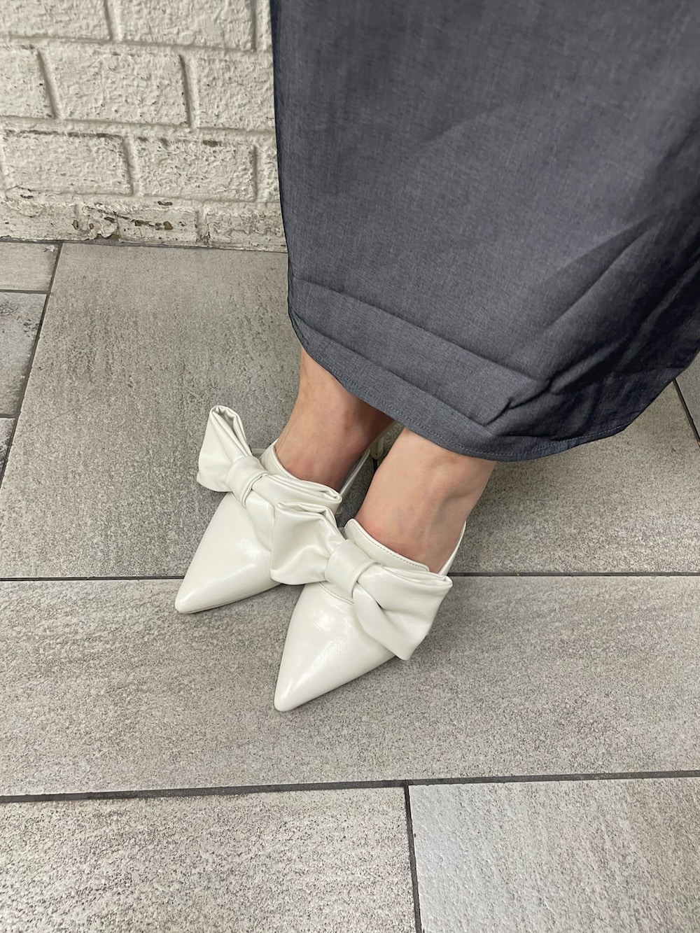 ブラック系のワンピース、ホワイト系のサンダル、ブルー系のバレッタ/ヘアクリップを着用したレディースの春コーディネートの5枚目の写真