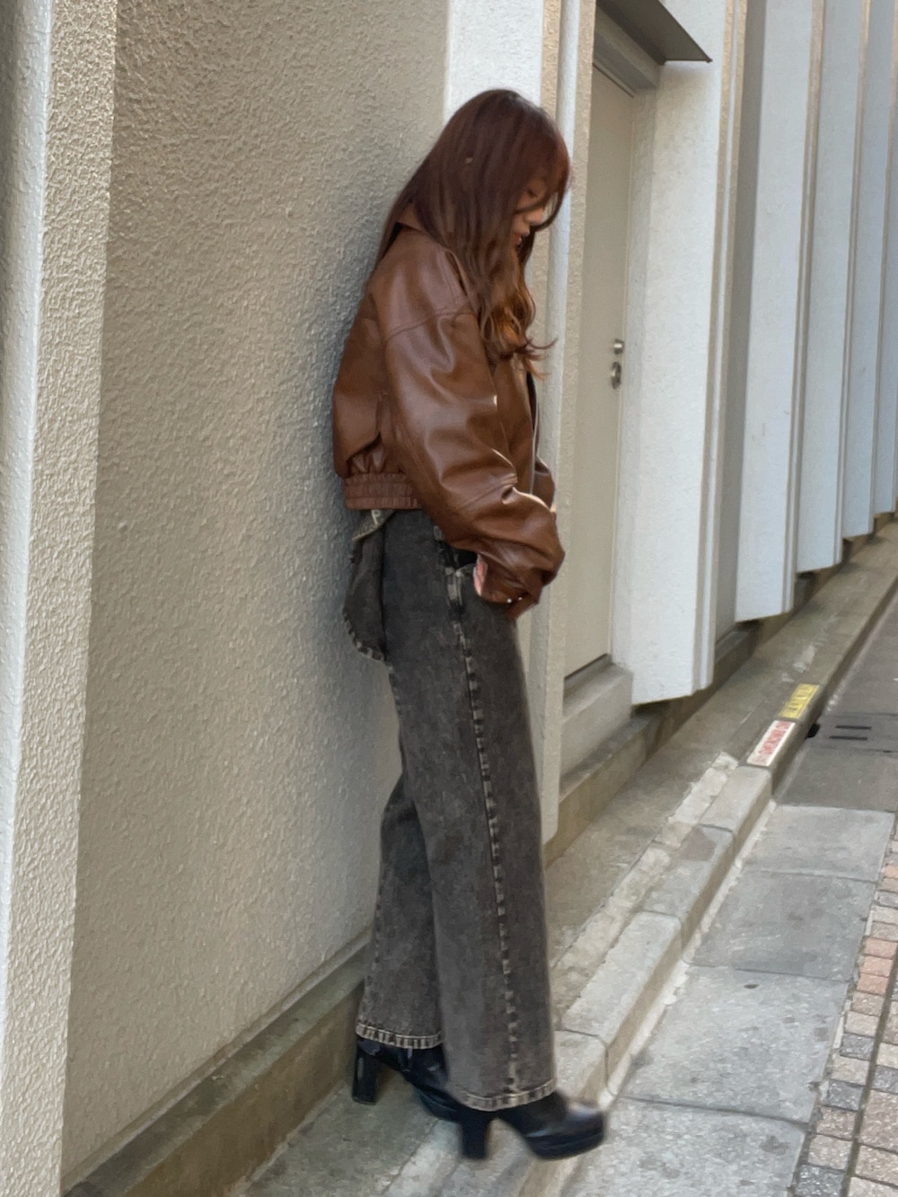 ブラウン系のブルゾン、ピンク系のニット/セーター、ブラック系のデニムパンツを着用したレディースの冬コーディネートの3枚目の写真