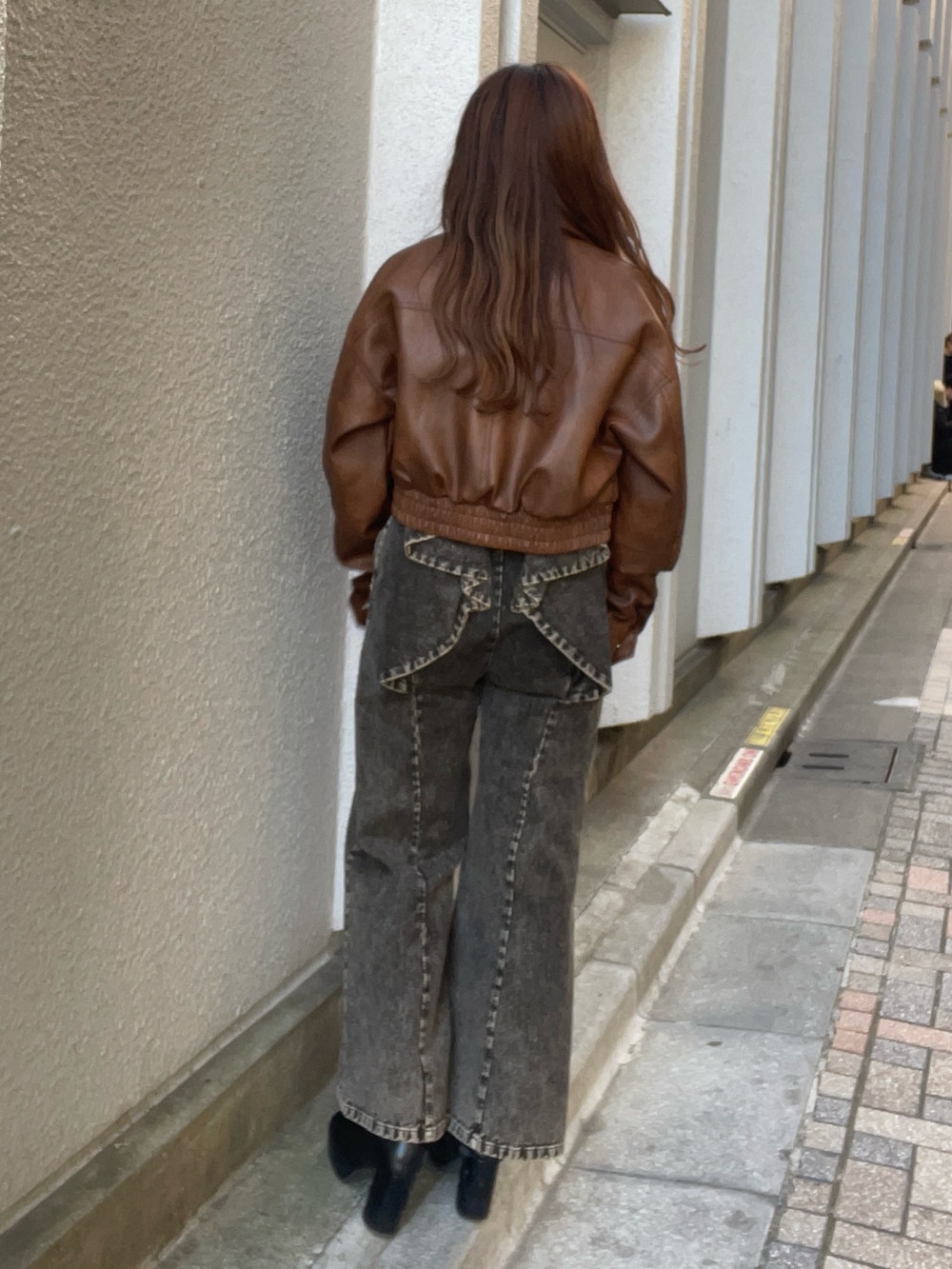 ブラウン系のブルゾン、ピンク系のニット/セーター、ブラック系のデニムパンツを着用したレディースの冬コーディネートの4枚目の写真