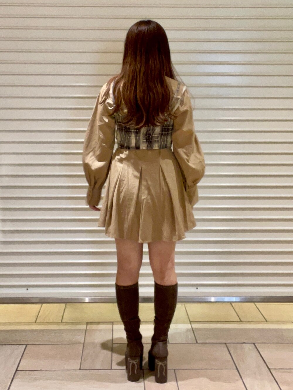 ブラウン系のキャミソール、ベージュ系のシャツワンピース、ブラック系のブーツを着用したレディースの秋コーディネートの4枚目の写真