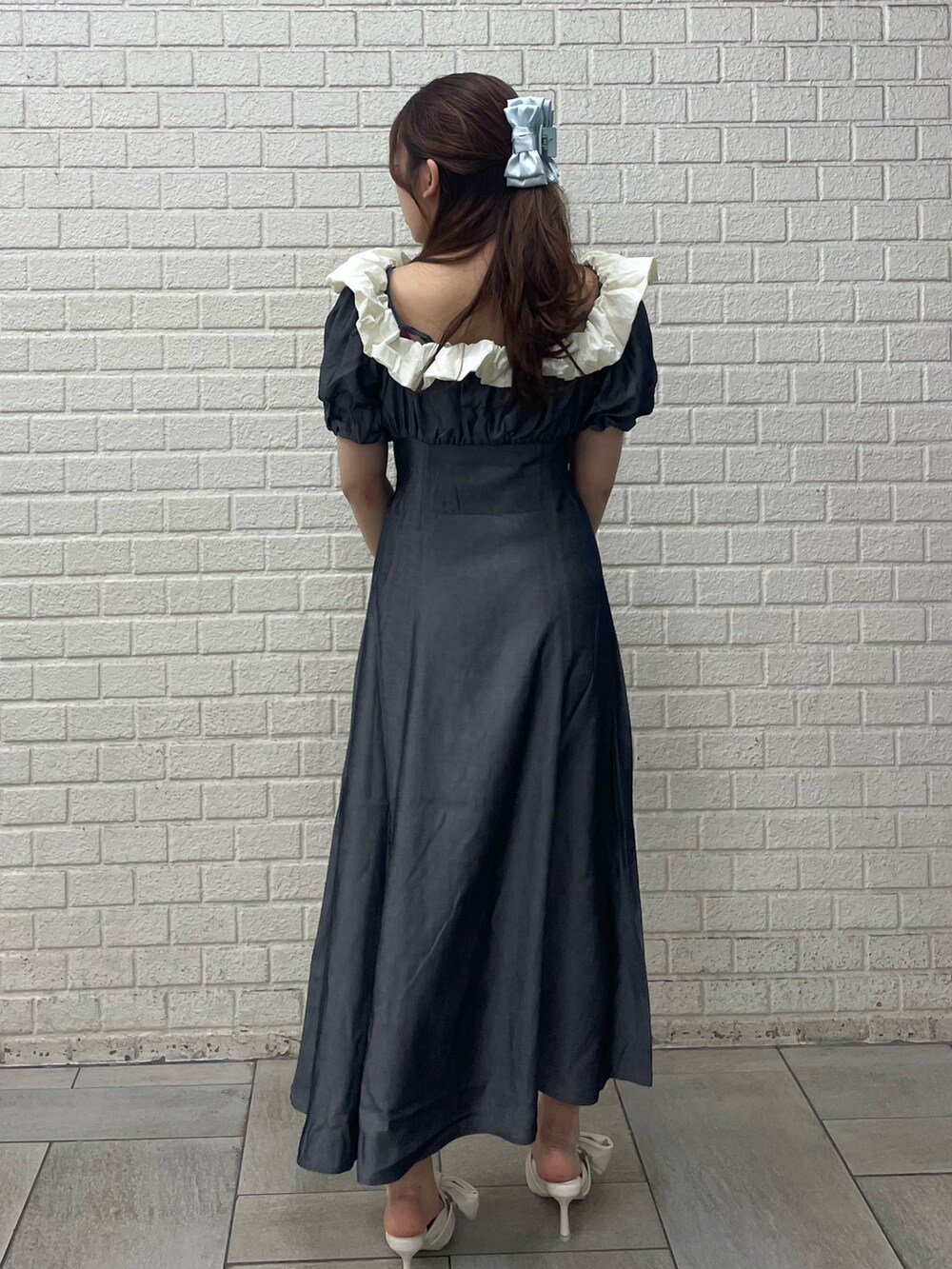 ブラック系のワンピース、ホワイト系のサンダル、ブルー系のバレッタ/ヘアクリップを着用したレディースの春コーディネートの3枚目の写真