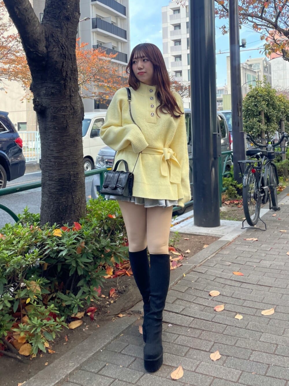 ブラック系のブーツ、イエロー系のニット/セーター、グレー系のその他パンツを着用したレディースの秋コーディネートの5枚目の写真