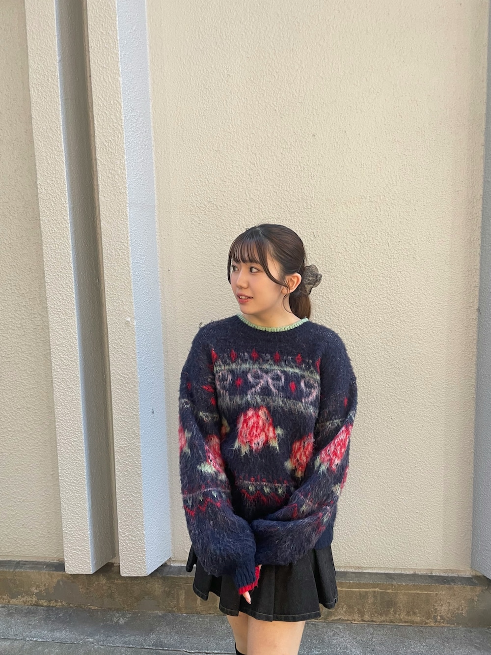 ブルー系のニット/セーター、ブラック系のスカート、ブラック系のブーツを着用したレディースの秋コーディネートの4枚目の写真