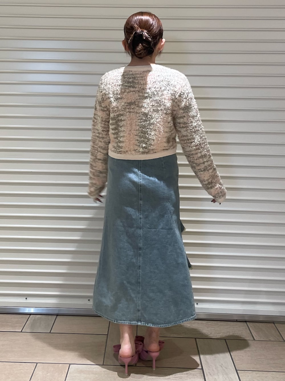 ピンク系のカーディガン/ボレロ、ブルー系のスカート、ピンク系のサンダルを着用したレディースの冬コーディネートの4枚目の写真