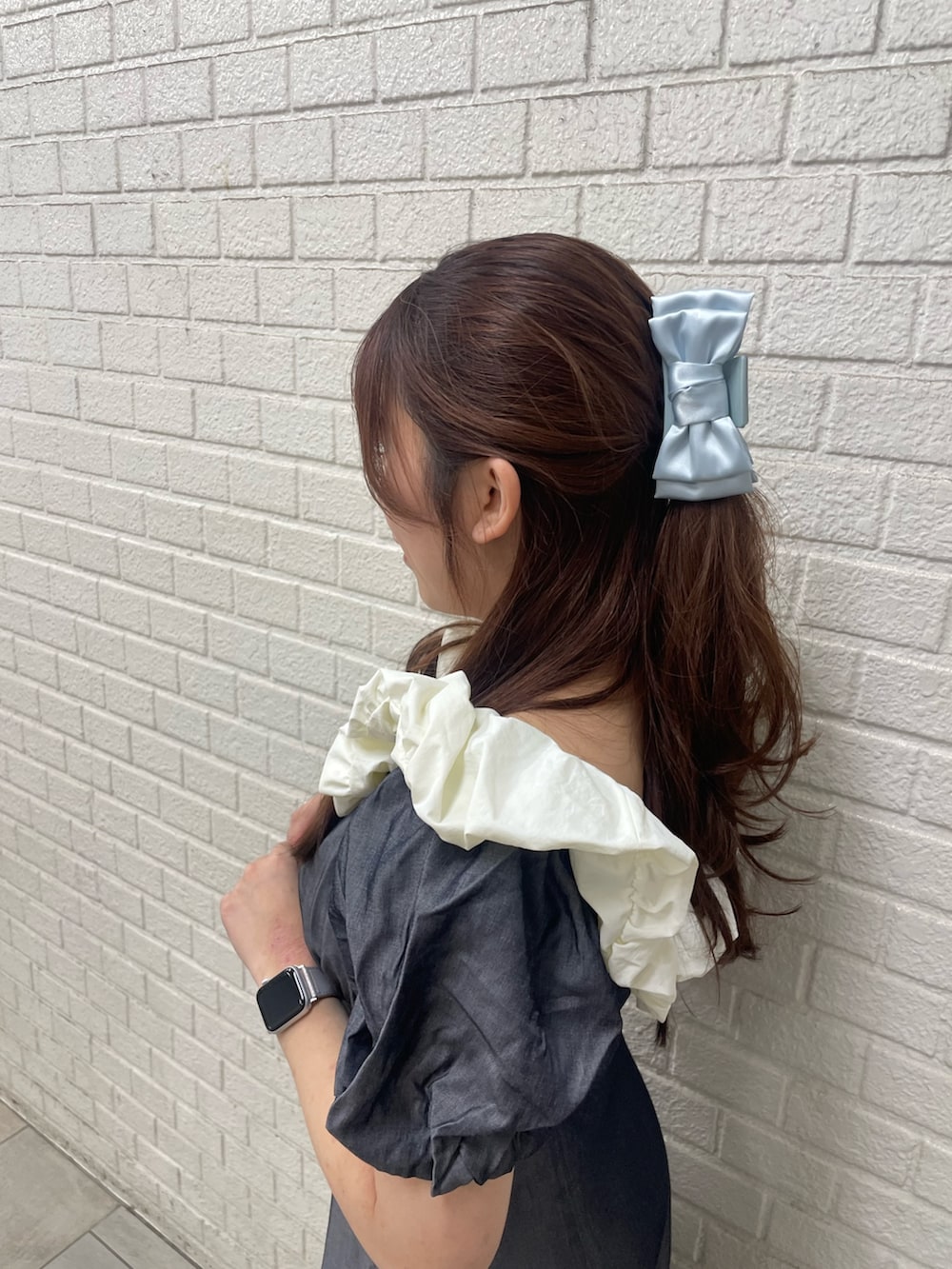 ブラック系のワンピース、ホワイト系のサンダル、ブルー系のバレッタ/ヘアクリップを着用したレディースの春コーディネートの4枚目の写真