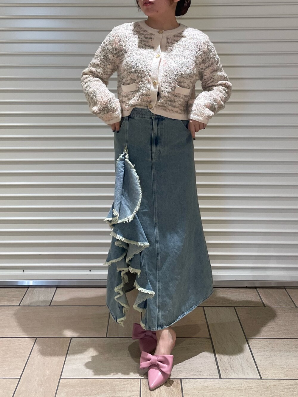 ピンク系のカーディガン/ボレロ、ブルー系のスカート、ピンク系のサンダルを着用したレディースの冬コーディネートの2枚目の写真