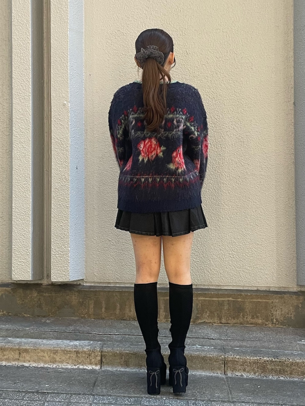 ブルー系のニット/セーター、ブラック系のスカート、ブラック系のブーツを着用したレディースの秋コーディネートの3枚目の写真