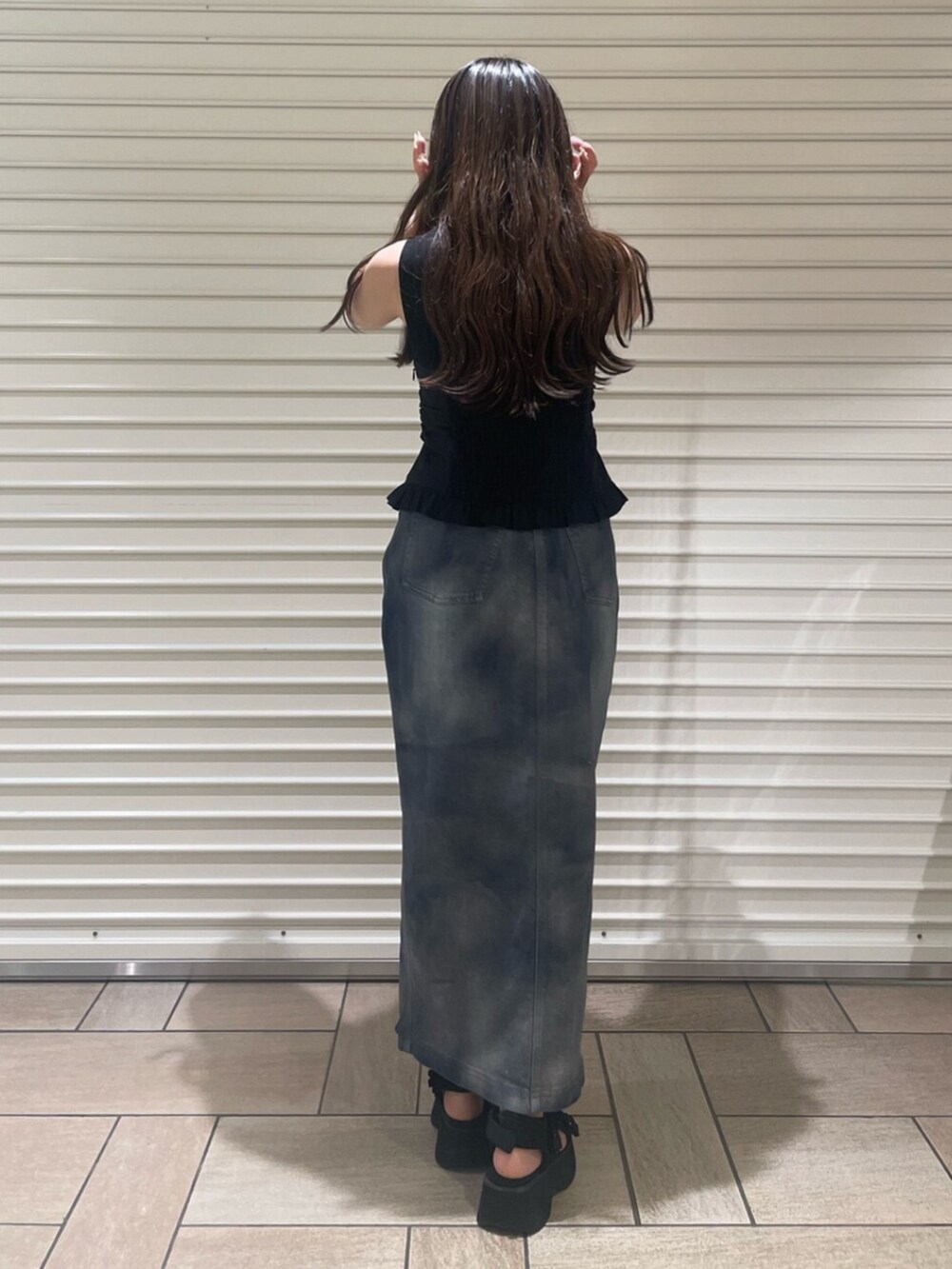 ブラック系のサンダル、ブルー系のスカート、ブラック系のTシャツ/カットソーを着用したレディースの夏コーディネートの3枚目の写真