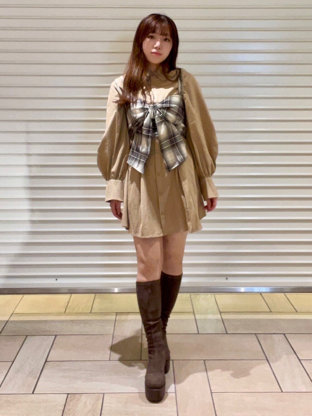 ブラウン系のキャミソール、ベージュ系のシャツワンピース、ブラック系のブーツを着用したレディースの秋コーディネートの2枚目の写真