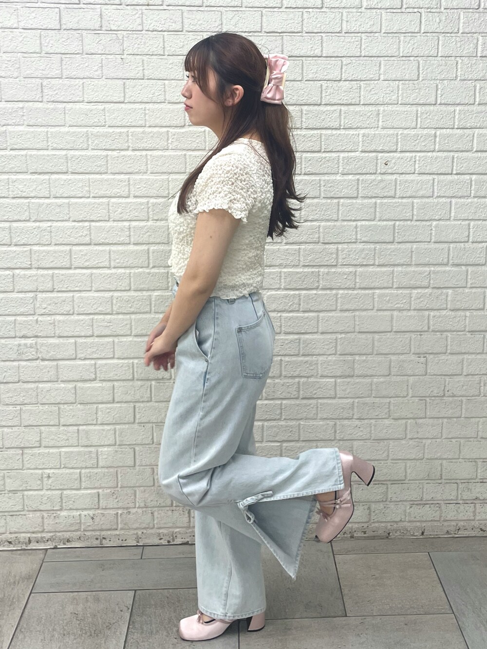 ピンク系のパンプス、ブルー系のデニムパンツ、イエロー系のTシャツ/カットソーを着用したレディースの春コーディネートの2枚目の写真