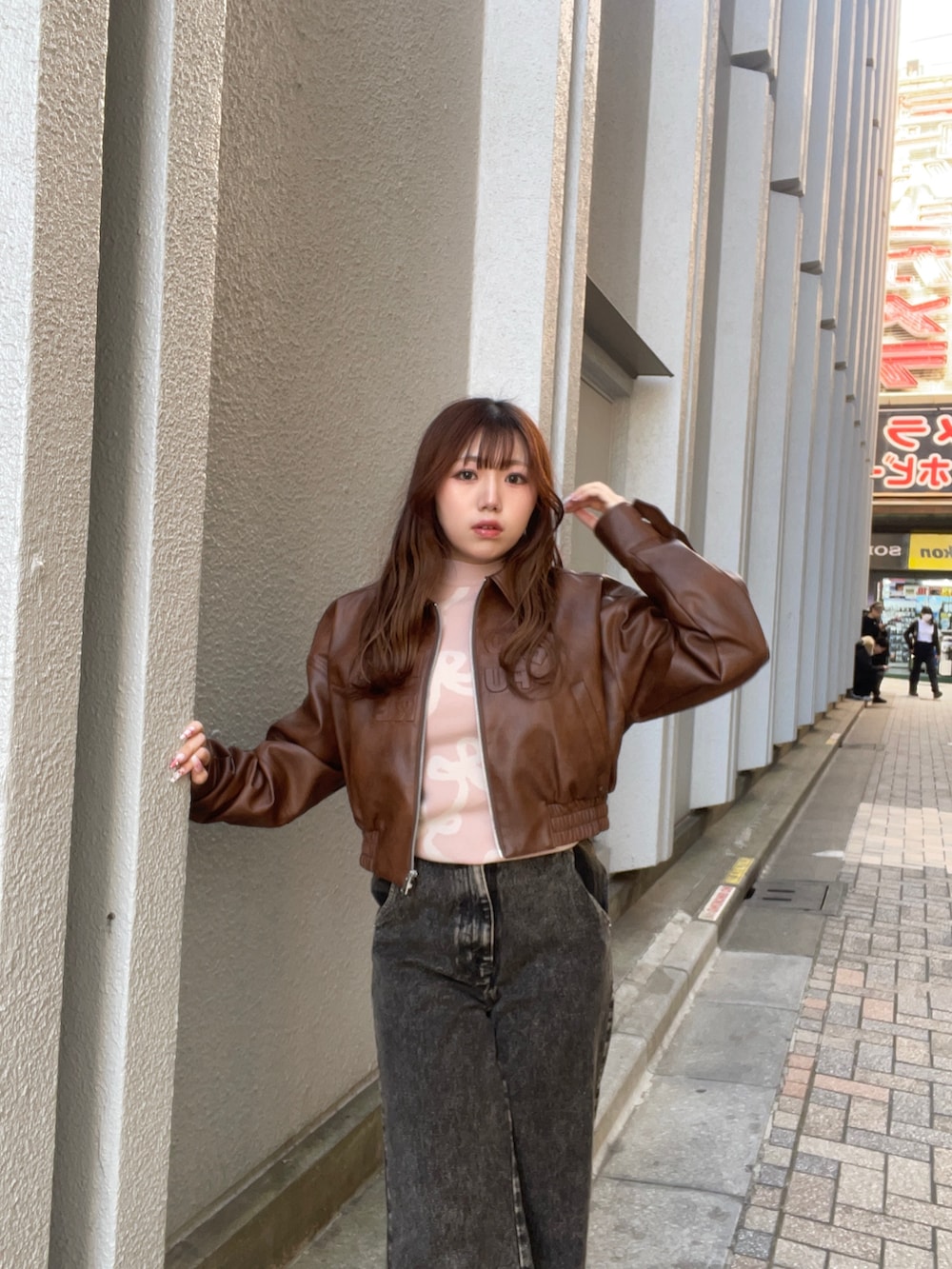 ブラウン系のブルゾン、ピンク系のニット/セーター、ブラック系のデニムパンツを着用したレディースの冬コーディネートの5枚目の写真