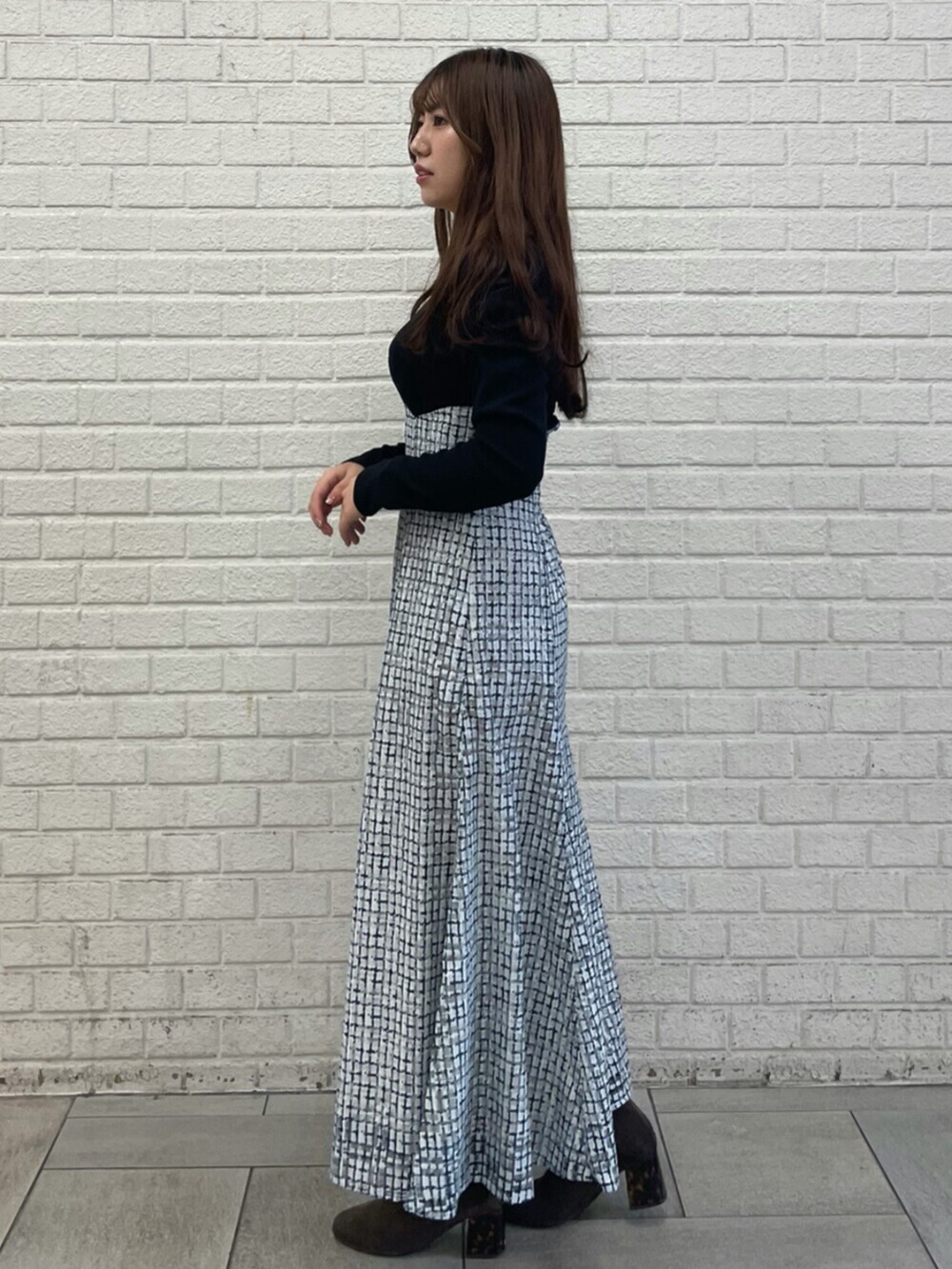 ブラック系のワンピースを着用したレディースの冬コーディネートの2枚目の写真