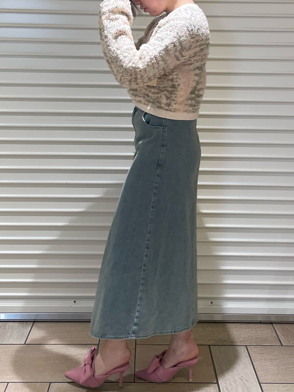 ピンク系のカーディガン/ボレロ、ブルー系のスカート、ピンク系のサンダルを着用したレディースの冬コーディネートの3枚目の写真