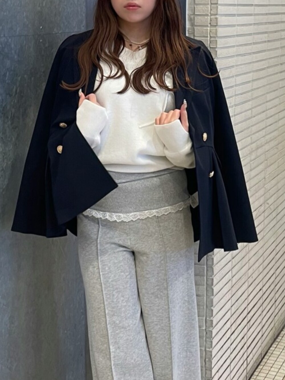 イエロー系のニット/セーター、ブルー系のノーカラージャケット、グレー系のその他パンツを着用したレディースの冬コーディネートの5枚目の写真