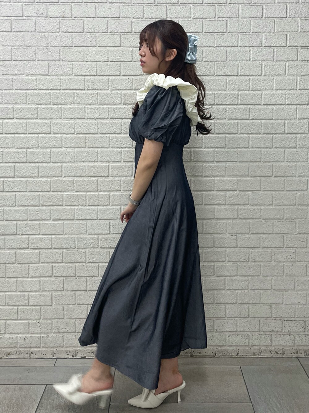 ブラック系のワンピース、ホワイト系のサンダル、ブルー系のバレッタ/ヘアクリップを着用したレディースの春コーディネートの2枚目の写真