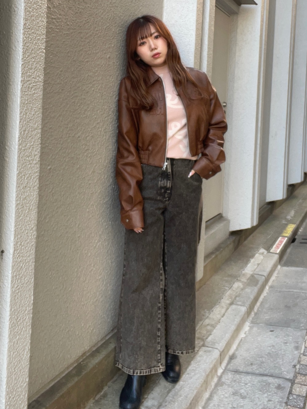 ブラウン系のブルゾン、ピンク系のニット/セーター、ブラック系のデニムパンツを着用したレディースの冬コーディネートの2枚目の写真