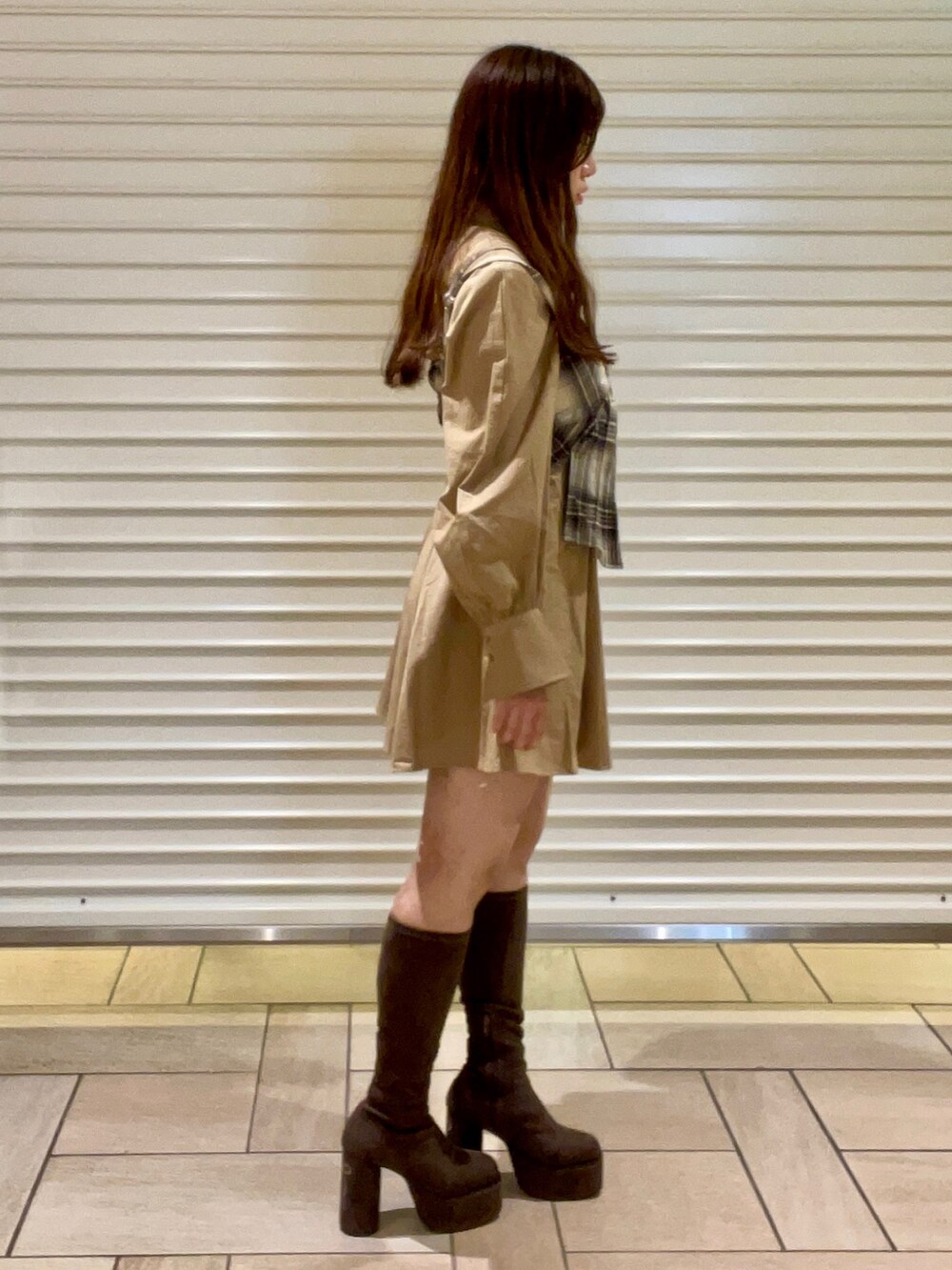 ブラウン系のキャミソール、ベージュ系のシャツワンピース、ブラック系のブーツを着用したレディースの秋コーディネートの3枚目の写真